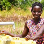 A woman gets clean water from the borehole at Rom village in Gulu, Uganda