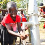 A girl gets clean water from the borehole at Rom village in Gulu, Uganda