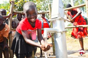 A girl gets clean water from the borehole at Rom village in Gulu, Uganda