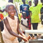 A girl gets clean water from the borehole at Rom village in Gulu, Uganda