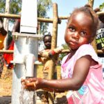 A child gets clean water from the borehole at Rom village in Gulu, Uganda