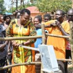 Community members getting clean water from the borehole at Rom village in Gulu, Uganda