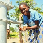 A child from Kal A 2 Ocega community, getting clean water from the borehole in Nwoya, Uganda