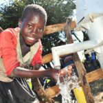 A child from Kal A 2 Ocega community, getting clean water from the borehole in Nwoya, Uganda