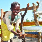 A child from Kal A 2 Ocega community, getting clean water from the borehole in Nwoya, Uganda