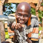 A man from Kal A 2 Ocega community, getting clean water from the borehole in Nwoya, Uganda