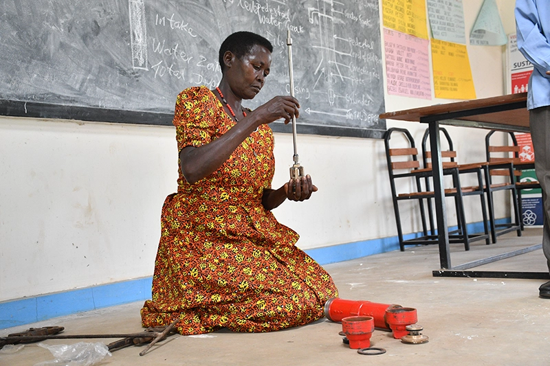 Local hand pump mechanics receiving practical maintenance and repair training