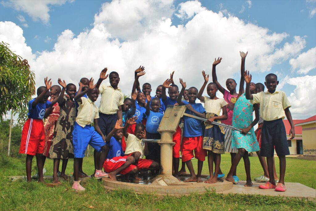A group pf children from Kumi, Uganda standing by the recently rehabbed well.