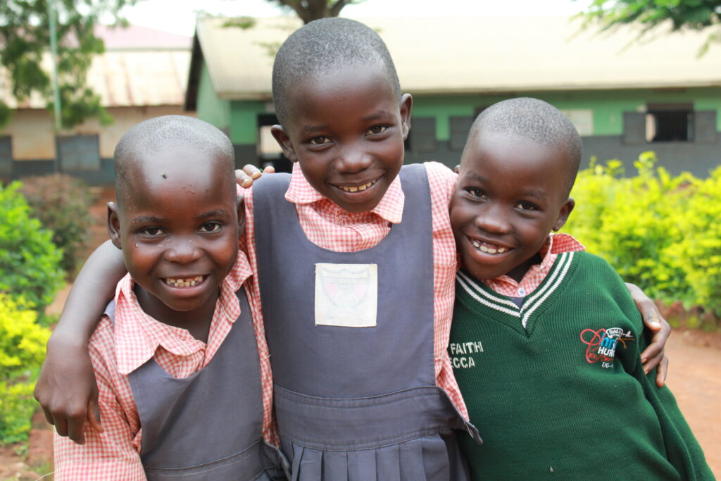 Three girls at a school with clean water in Uganda