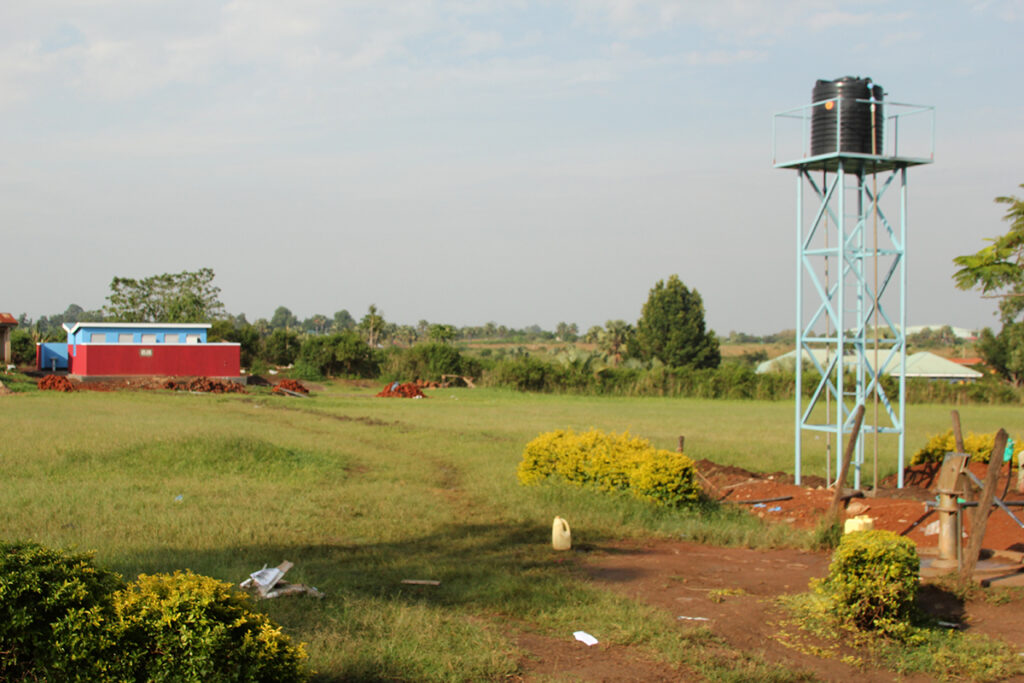 a school in Uganda with a well, a roundabout pump, toilets and a water tower - system designed by Drop in the Bucket