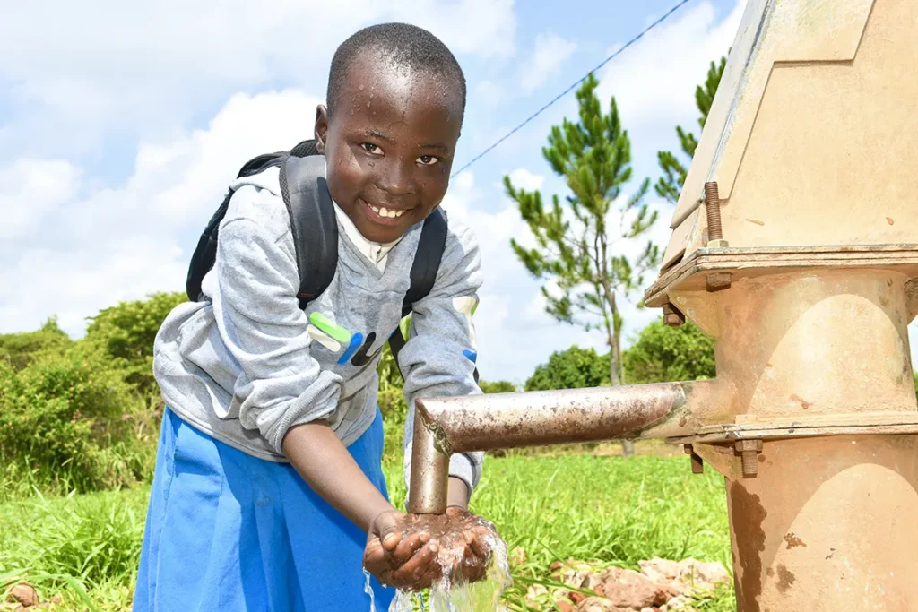 A boy gets clean water from a borehole in Uganda