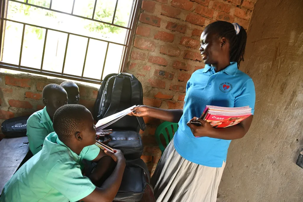 A teacher at the Green Valley Primary School in Nimule, South Sudan hands out new exercise books to her class.